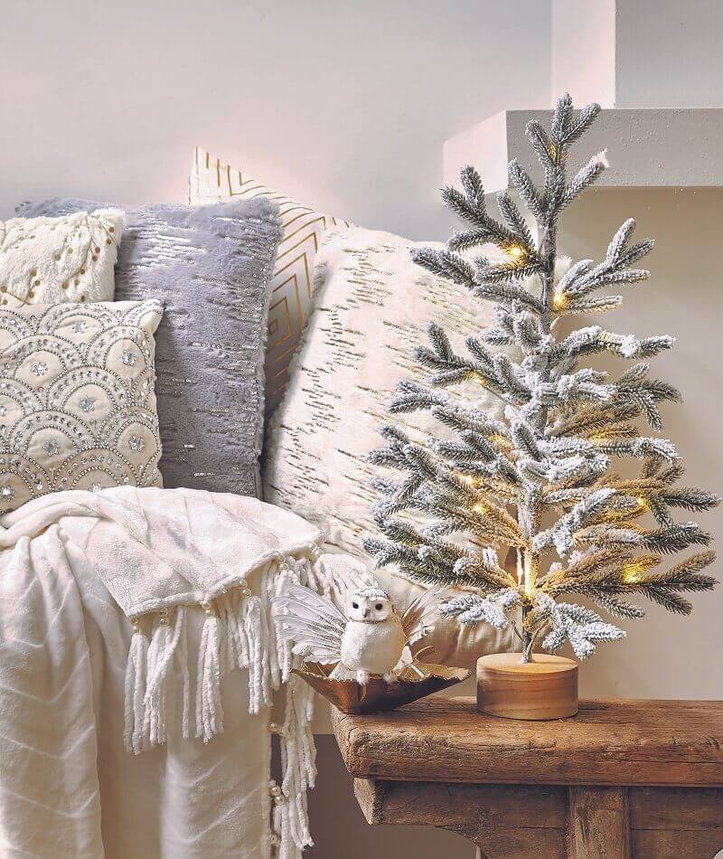 small Christmas tree with snow,winter decor for living room modern,decorative cushion in neutral covers,apartment living room Christmas décor,creative Christmas tree decorating ideas,