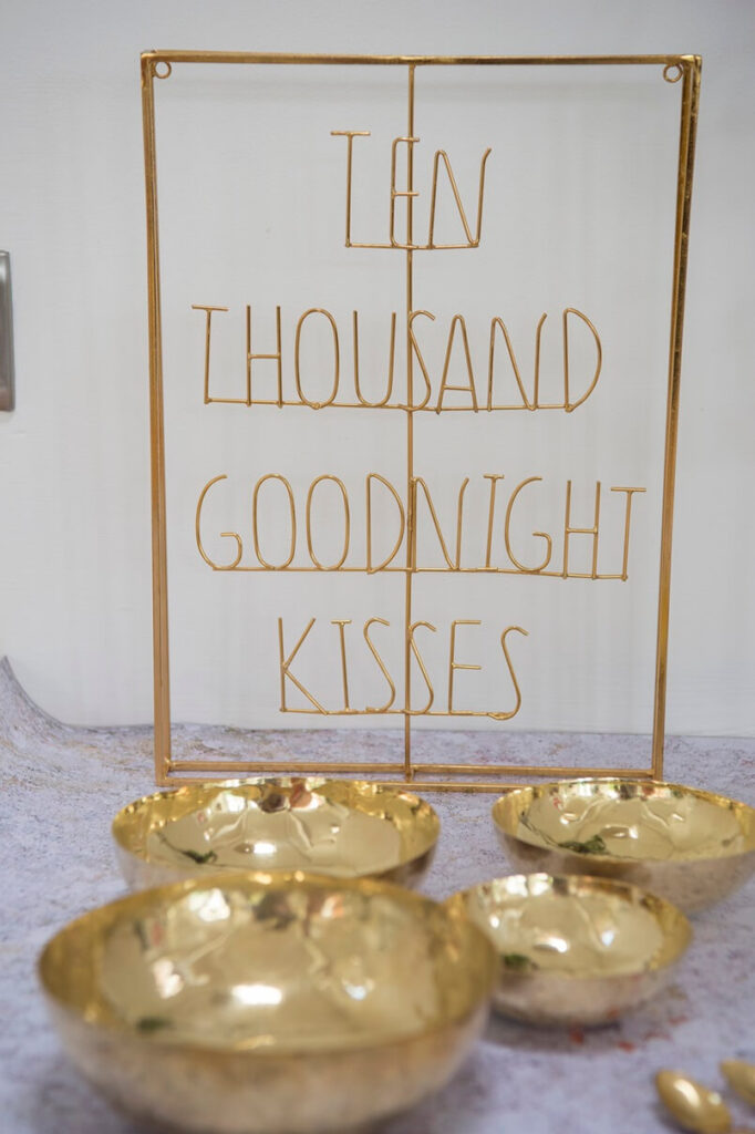 gold wire sign saying Ten thousand goodnight kisses, romantic bedroom decor